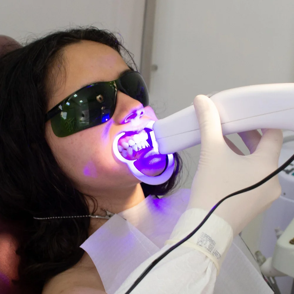 Female patient receiving an in-office teeth whitening procedure with LED whitening technology