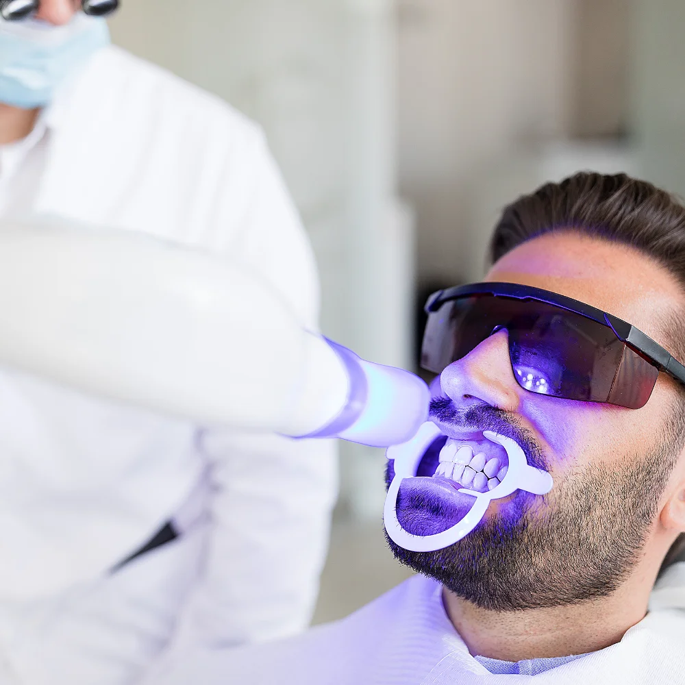 Patient receiving professional LED teeth whitening treatment for a brighter and whiter smile