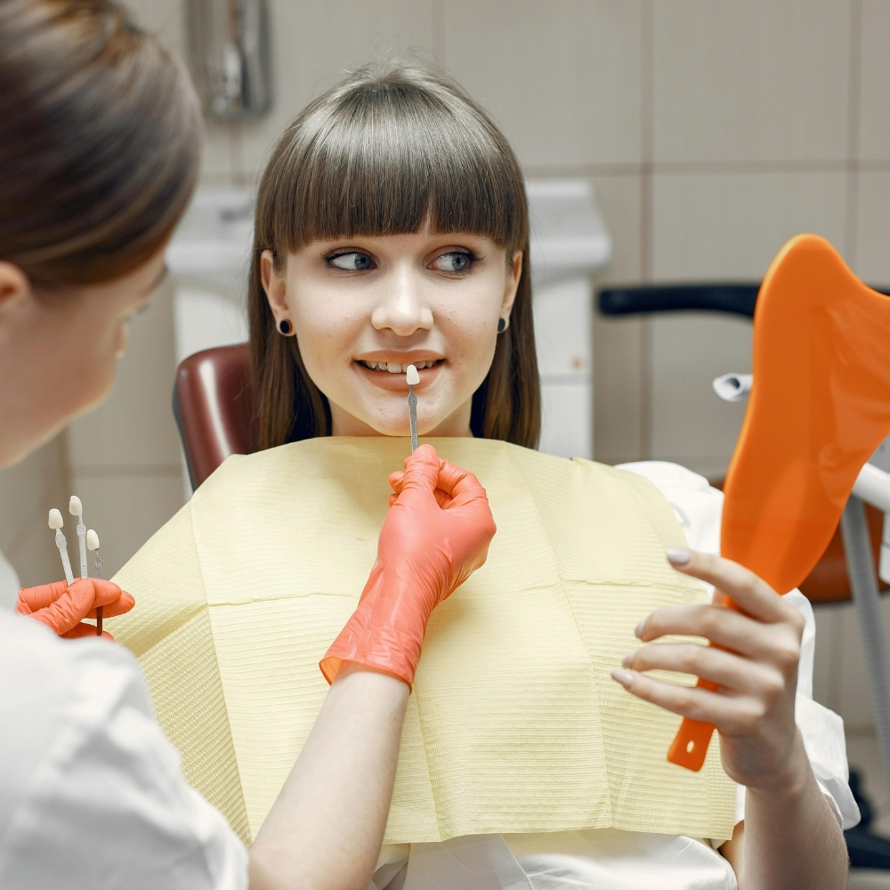 Dentist discussing veneer shade options with a patient during a cosmetic smile consultation