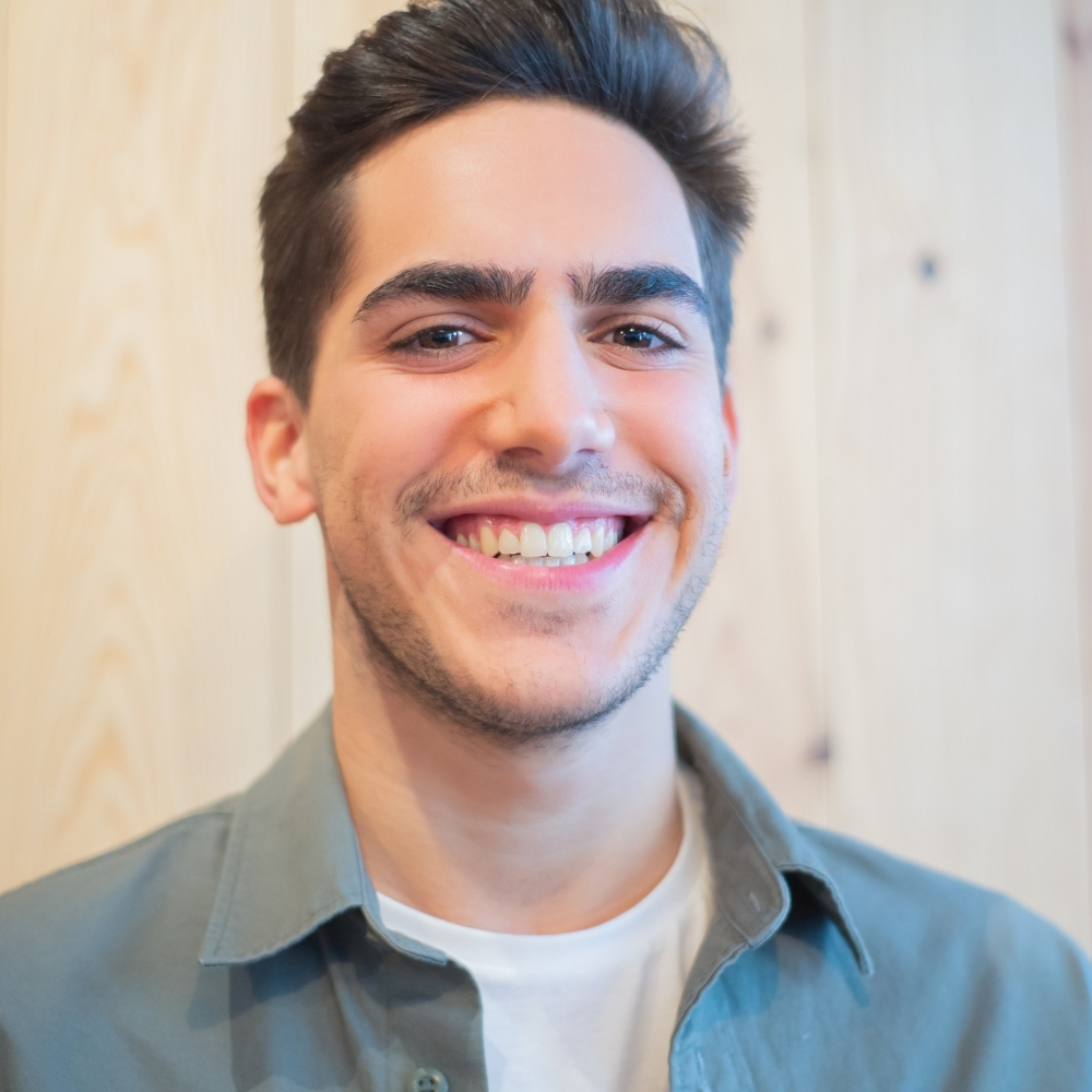 Young man smiling confidently after improving his smile with cosmetic dental veneers