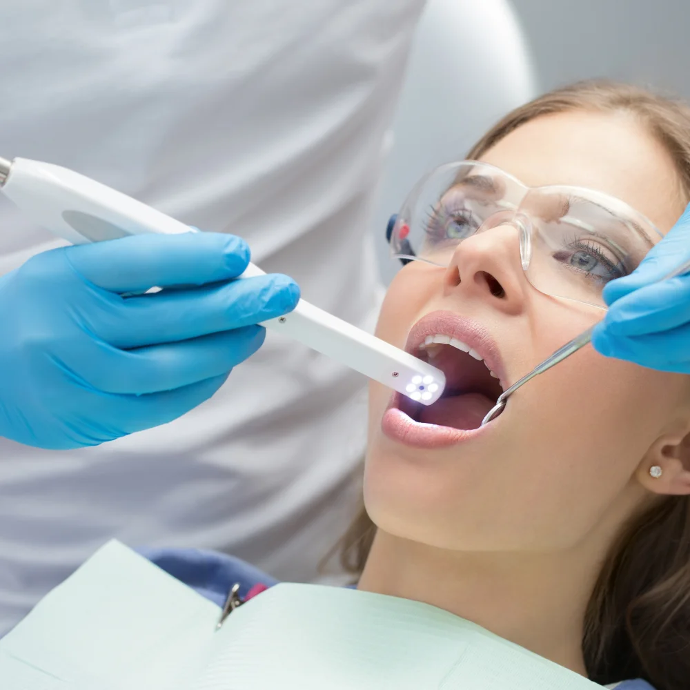 Female patient receiving comfortable sedation dentistry treatment during a dental procedure with protective eyewear