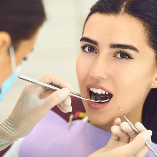 Dentist performing a cosmetic dental check-up on a female patient during her appointment