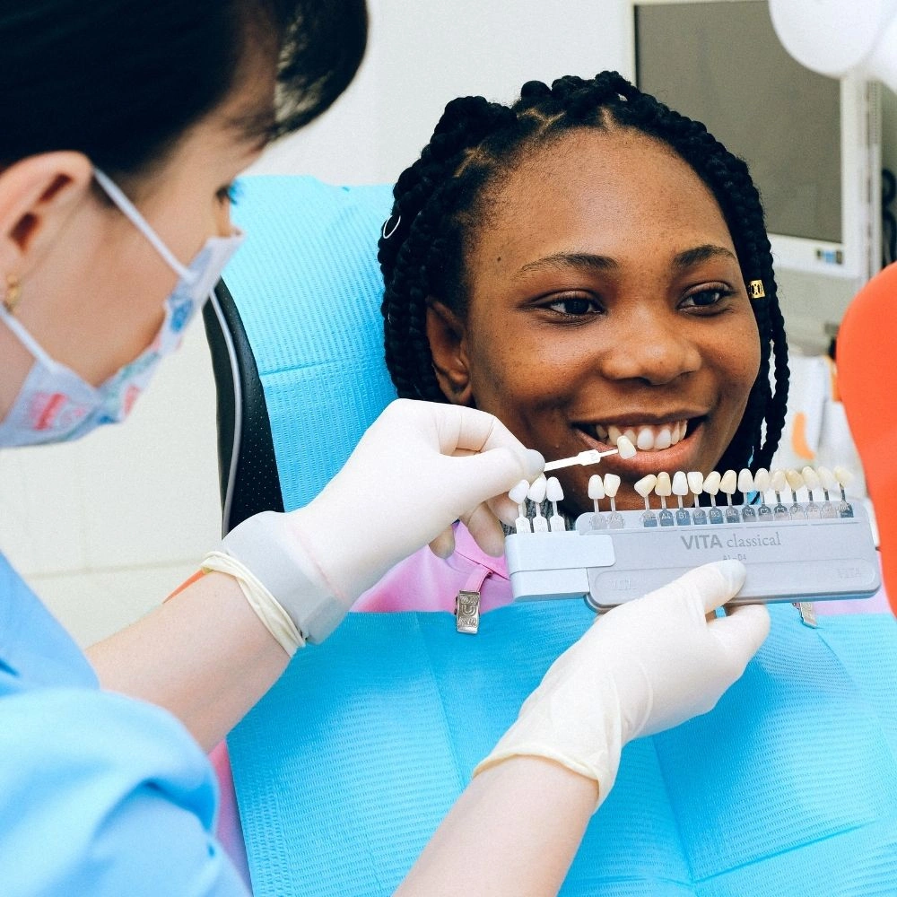 Dental professional comparing veneer shades to create a natural-looking smile restoration